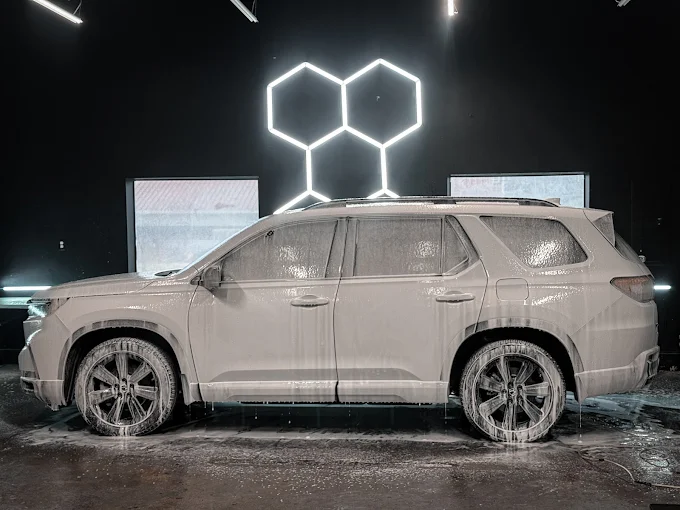 SUV covered in foam during a hand wash in the bay