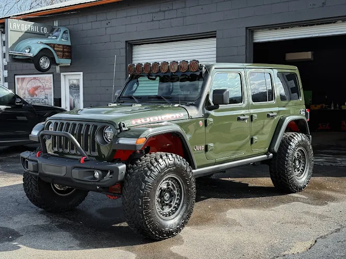 Green Jeep Wrangler Rubicon with a light bar, freshly cleaned