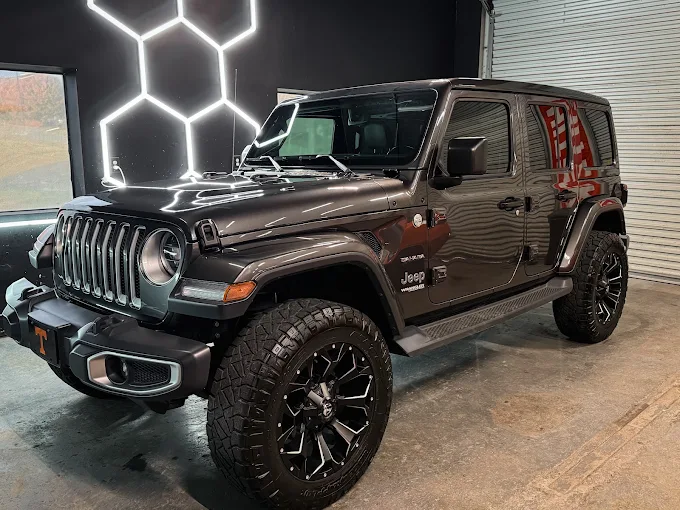 Jeep Wrangler with mirror-like reflections of the shop lights
