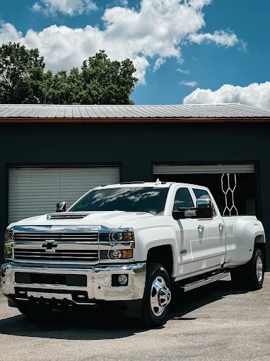 White Chevy Silverado dually parked in front of the shop
